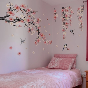 Detail of pink cherry blossom wall stickers with birds in a bedroom corner setting