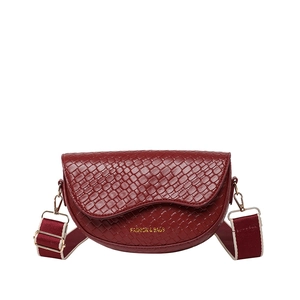 Burgundy saddle bag with woven texture, wide strap, and gold metal buckle on white background