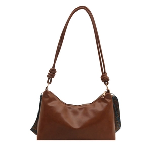 Caramel brown crescent shoulder bag with pleated texture and decorative silk scarf