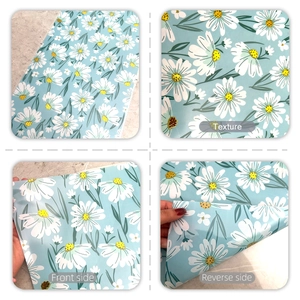 Detailed view of daisy print fabric texture with front and reverse side on marble surface