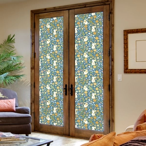 Detail of floral rabbit static window film on glass doors in a cozy living room scene