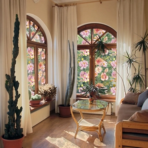 Artistic window film with pink and yellow floral patterns on arched glass in a sunlit room