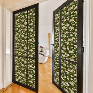 Detail of floral window film featuring pink flowers on dark green background for glass doors