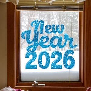 Blue New Year 2026 window cling with white polka dots on a snowy glass window scene