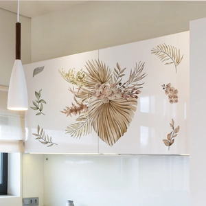 Detail of bohemian floral and palm leaf stickers on white kitchen cabinets decor