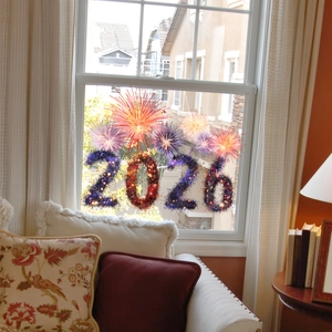 Detail of 2026 New Year firework window cling applied on glass in a cozy home setting
