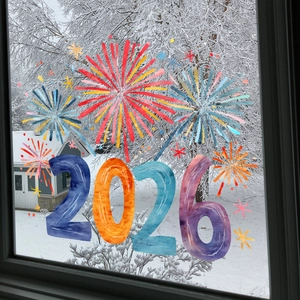Close-up of 2026 New Year firework window decals applied to glass with winter view