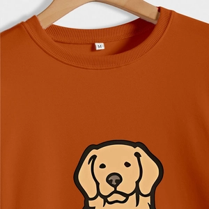Detail of pumpkin orange crew neck sweatshirt featuring cute golden retriever graphic