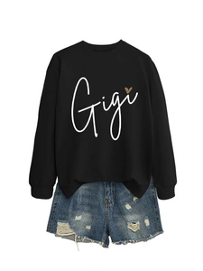 Détail du motif cœur léopard Gigi sur un sweat noir surdimensionné avec un short en jean