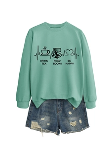 Detail of mint green sweatshirt with tea and book print paired with distressed denim shorts