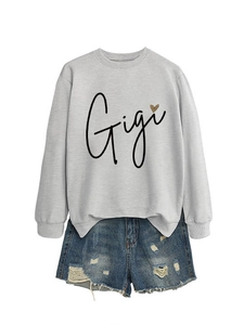 Détail du sweat gris Gigi avec imprimé cœur léopard et short en jean décontracté