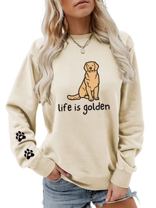 Close-up of paw print pattern on the sleeve of a cream life is golden sweatshirt
