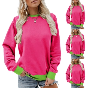Detail of pink sweatshirt featuring vibrant green ribbed crewneck and matching cuffs