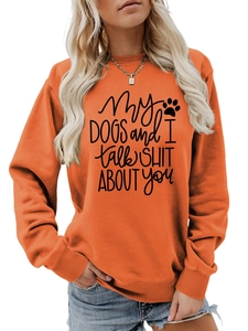 Close-up of orange crewneck sweatshirt featuring black dog-themed slogan and paw print
