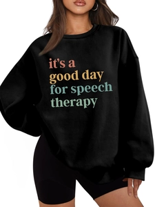 Detalle del eslogan colorido impreso en una sudadera negra oversize de felpa para mujer