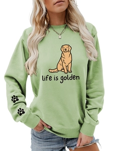 Detail of light green sweatshirt sleeve featuring two black paw print graphic designs