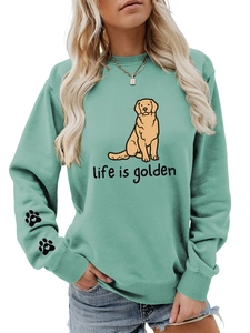 Detail of mint green sweatshirt featuring golden retriever print and arm paw patterns