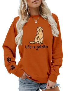 Detail of caramel crewneck sweatshirt featuring golden retriever print and heart paw on sleeve