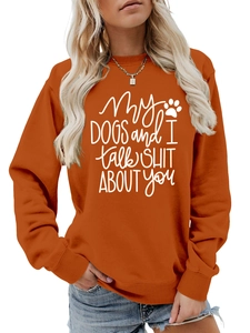 Close-up of bright orange crewneck sweatshirt featuring a funny dog-themed white slogan