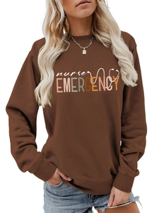 Détail des poignets côtelés et de l'imprimé Nurse Emergency sur un sweat marron