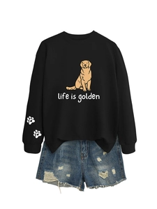 Flat lay of a black long-sleeved sweatshirt with a golden retriever print and denim shorts