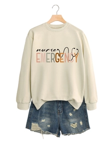 Détail du sweatshirt crème nurse emergency avec un short en jean bleu délavé