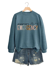 Détail d'un sweat bleu avec imprimé Nurse Emergency et short en jean vieilli