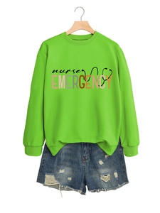 Détail du sweat vert Nurse Emergency avec short en jean sur un cintre en bois
