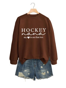 Detail eines dunkelbraunen Hockey Nana Sweatshirts mit zerrissenen Denim-Shorts kombiniert