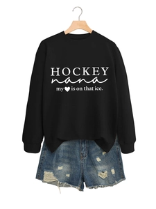 Detail eines schwarzen Sweatshirts mit weißer Aufschrift und Jeans-Shorts mit Rissen