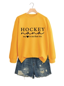 Detail eines hellgelben Sweatshirts mit Hockey Nana Schriftzug und einem Rundhalsausschnitt