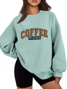 Detail of light teal oversized sweatshirt featuring Coffee Weather graphic print