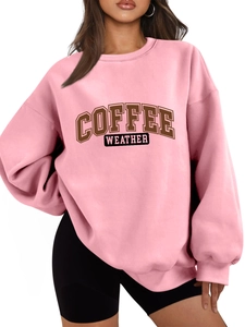 Close-up of pink oversized sweatshirt featuring Coffee Weather vintage lettering