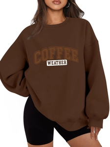 Detail of the oversized brown sweatshirt showing the Coffee Weather vintage college lettering