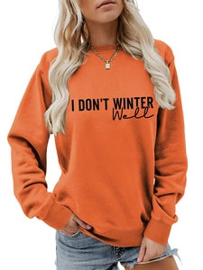Detail view of the ribbed neckline and black graphic lettering on orange sweatshirt
