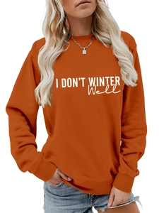 Detail of pumpkin orange sweatshirt featuring I DON'T WINTER WELL white script font print