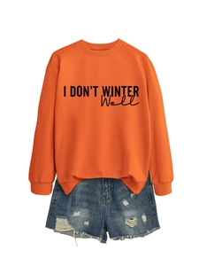 Detailed close-up of orange sweatshirt print and blue distressed denim shorts set