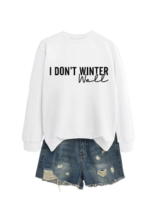 Flat lay of a white sweatshirt with 'I DON'T WINTER Well' text and denim shorts