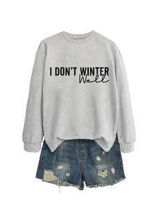Flat lay of gray I Don't Winter Well sweatshirt paired with distressed blue denim shorts
