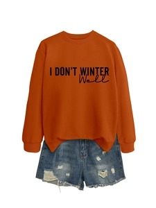 Flat lay of an orange sweatshirt with I DON'T WINTER WELL print and distressed denim shorts
