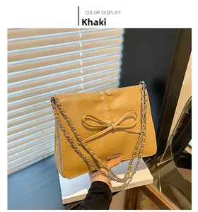 Detail shot of khaki bow tote bag featuring pleated PU leather and silver chain strap