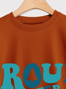 Détail du sweat-shirt caramel avec col rond côtelé et motif graphique de sapins