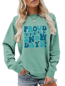 Détail du sweat sarcelle avec imprimé Proud Supporter of Snow Days et motifs de sapins