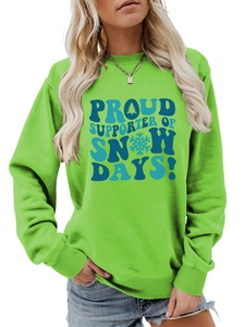 Détail du sweat vert col rond avec imprimé Proud Supporter of Snow Days et flocons
