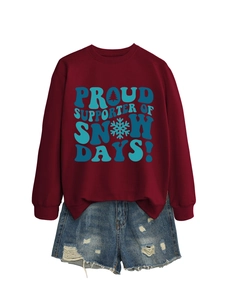 Détail de l'imprimé graphique bleu sur un sweat bordeaux avec flocons et motifs de sapins