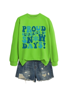 Détail d'un sweat-shirt vert imprimé Proud Supporter of Snow Days et d'un short en jean