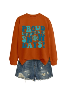 Détail du sweat-shirt orange avec texte bleu Proud Supporter of Snow Days et short en jean