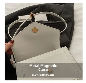 Détail du fermoir magnétique et des coutures précises sur le sac en cuir blanc