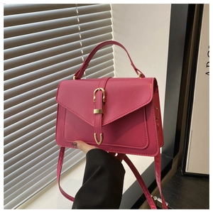 Detail of trendy rose pink handbag with golden horseshoe buckle and textured PU leather