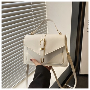 Detail of white PU leather handbag featuring vintage gold buckle and slim shoulder strap